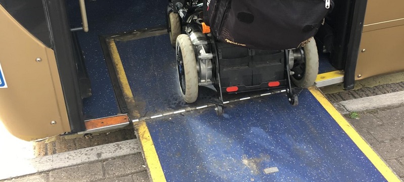 Picture of a wheelchair user going up a ramp onto the bus.