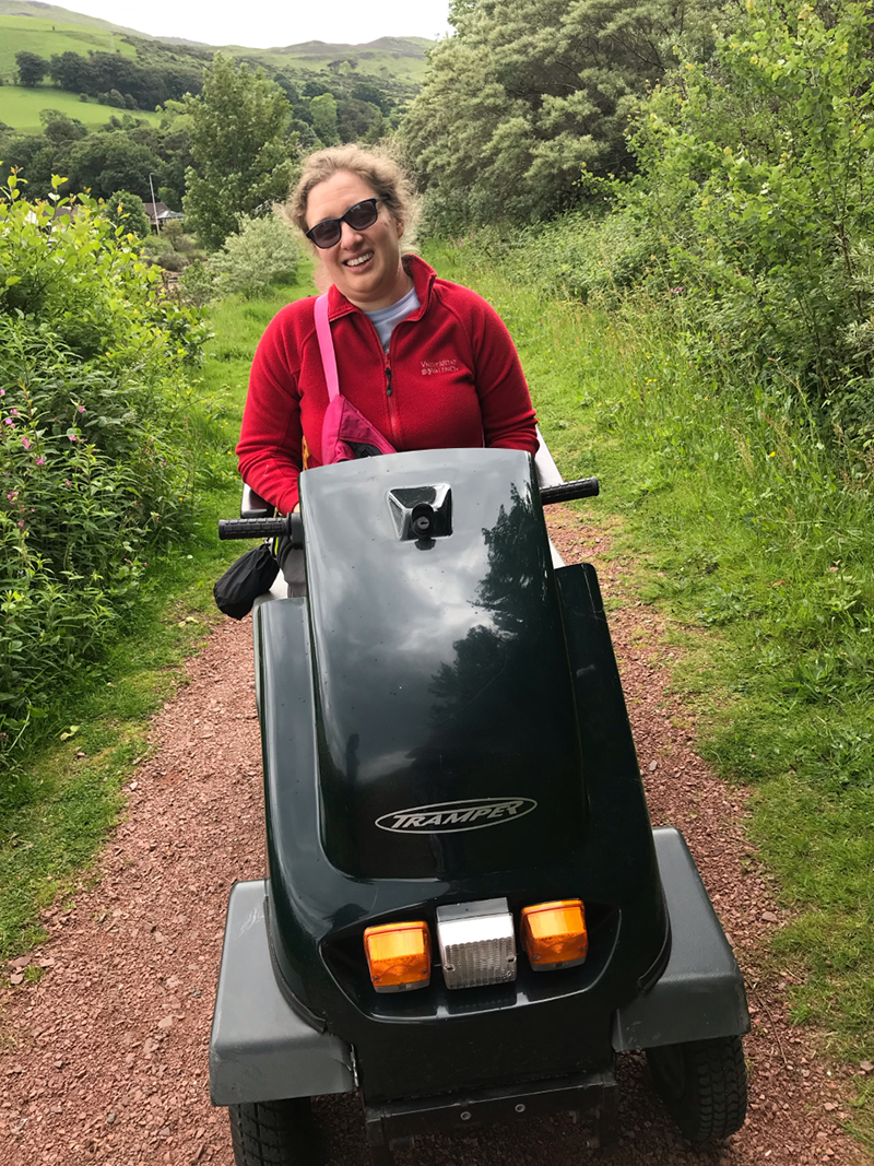 Photo of Zoe using an all terrain mobility scooter.