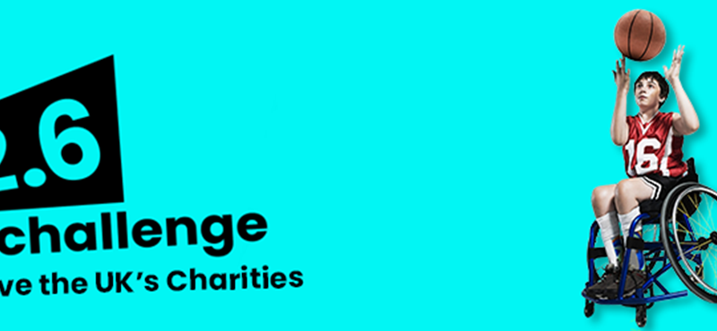 Blue background with a young boy in a sports wheelchair playing basketball on the right hand side. On the left side, the words 'The 2.6 Challenge: Save the UK's charities" is in black.