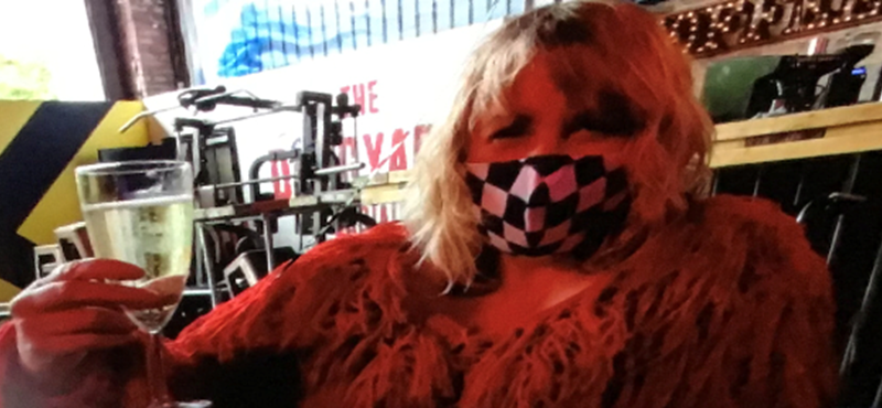 Image of Kim with a mask on and a drink in her hand
