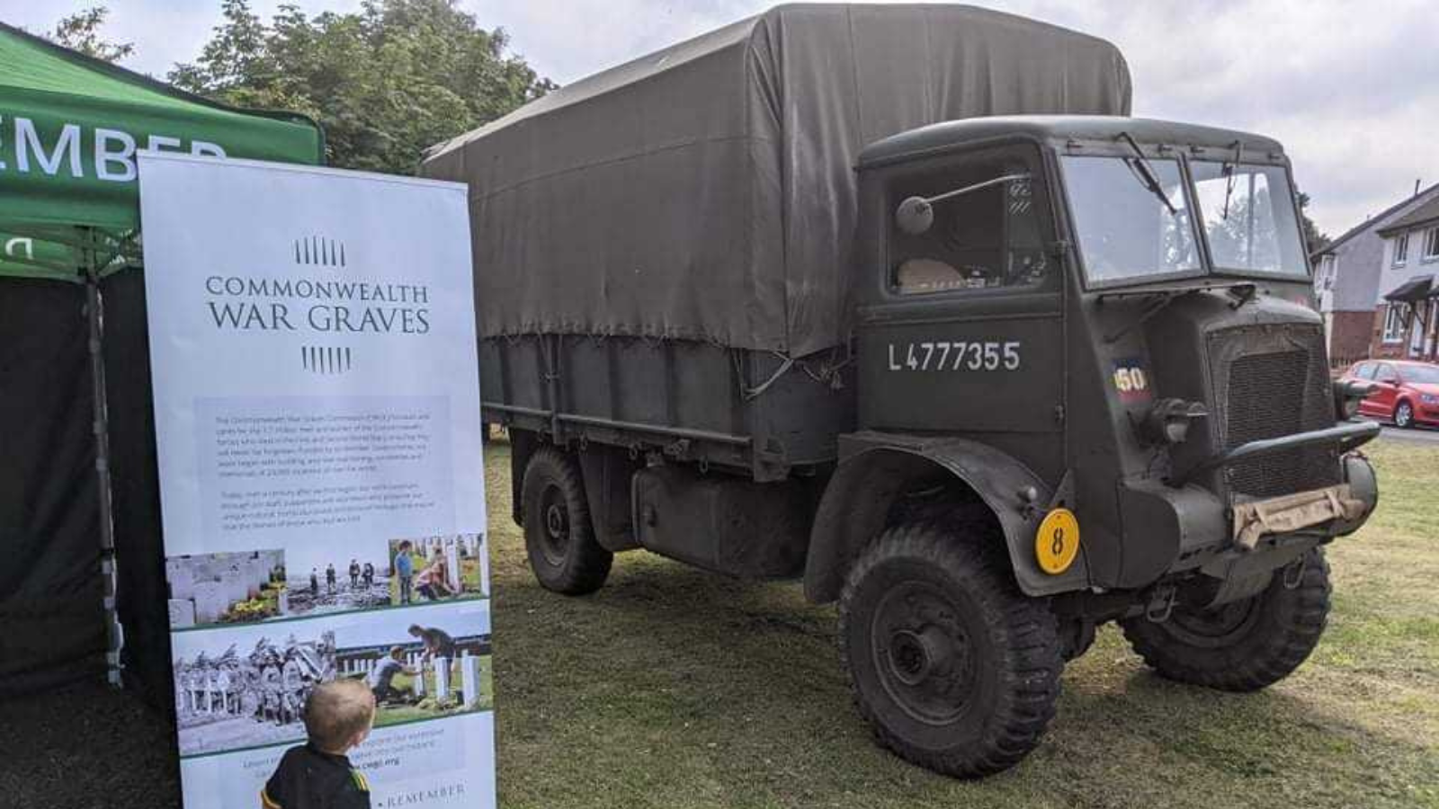 Image of a military vehicle with an information banner sign next to it telling you about the Commonwealth War Graves.