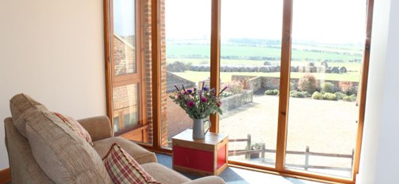 A photo of a room with large windows overlooking the countryside.