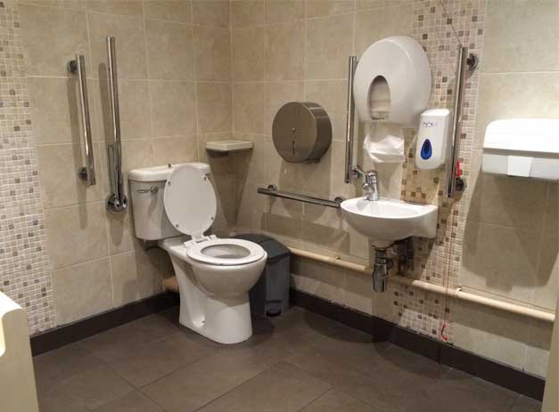 A photo of a tiled accessible toilet