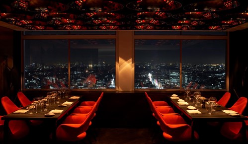 Photo of an empty restaurant looking out over a city.
