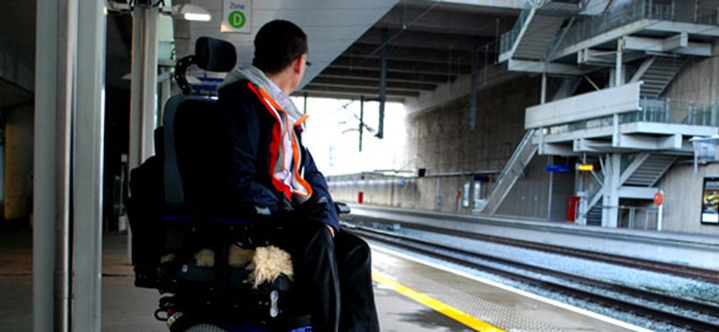 A photo of a man on a train station platform.
