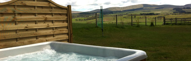 A photo of a hot tub in a field. 