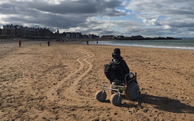 Photo of a wheelchair user at the beach.