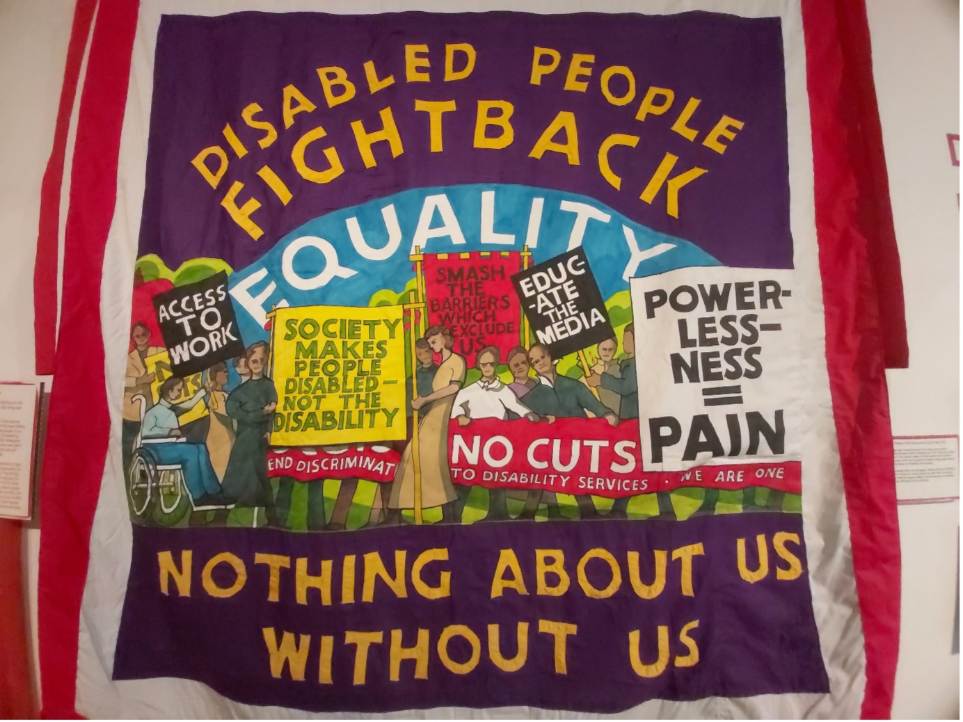 An image of a material with an image of a protest on it with text 'disabled people fight back' 'equality' 'powerless-ness = pain' 'nothing about us without us'
