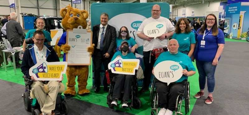 A photograph of the Euan's Guide staff and volunteers with Motability Operations CEO and mascot Billy the Bear