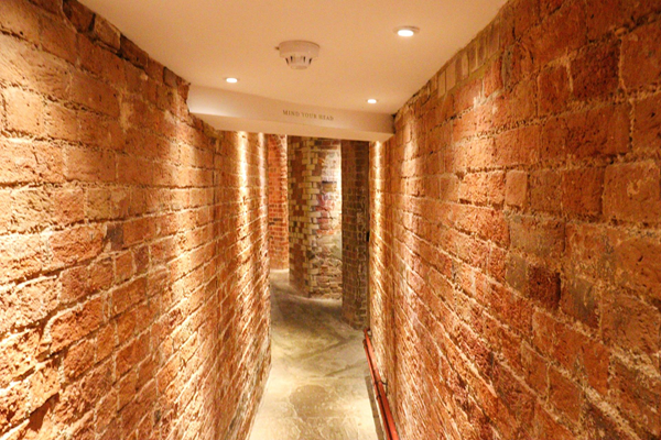 Narrow brick corridor, well lit