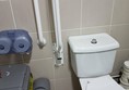 Emergency pull cord and toilet roll holder out of reach from toilet