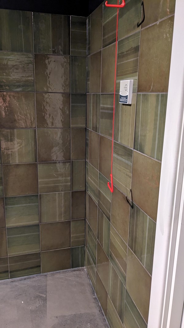 Red chord in bathroom unobstructed and hanging but doesn't even nearly reach the floor. Hopefully they will fix this soon!
