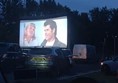Drive in Movie screen with Grease on it. Scene has John Travolta and Olivia Newton John on it as Danny and Sandy