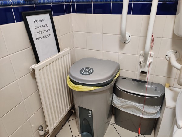 Accessible toilet with a sign telling everyone to leave the red emergency cord hanging free so that it can be reached in the event of emergency.