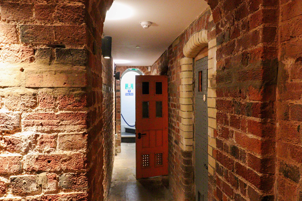 Narrow corridor with cell doors from it