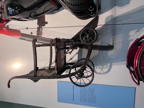 A historic wheelchair. Whicker chair on wheels.