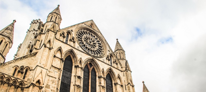 Angled photo of York Minster so you can see the top of the building and the sky above.