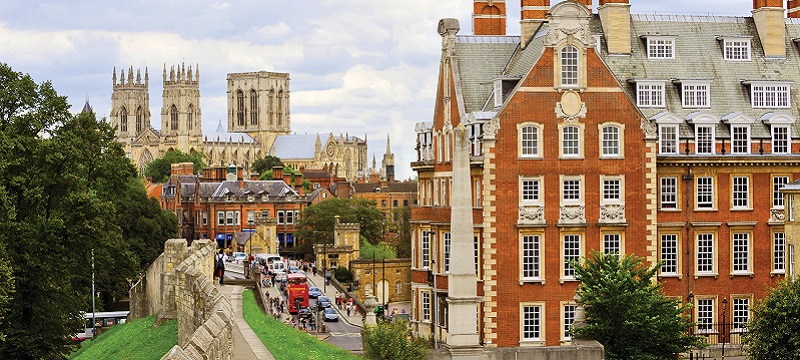 Photo of the exterior of The Grand Hotel and Spa. Iconic York landmarks can be seen around it, like the Minster and the city walls.