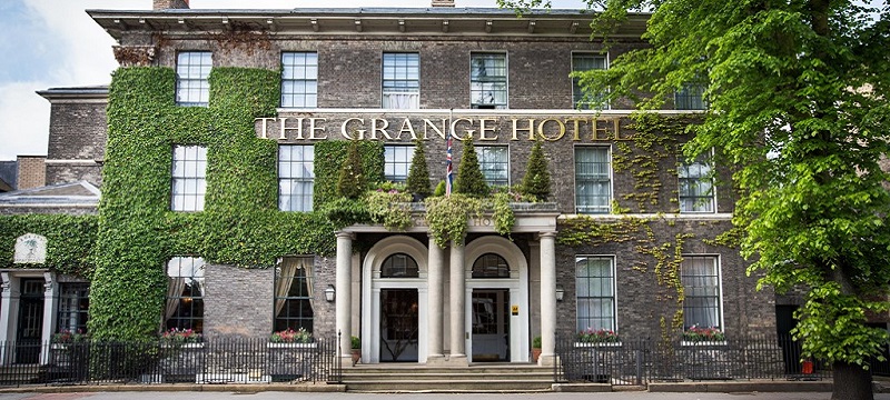 Exterior of the Grange Hotel with steps leading to a grand porch and ivy covered walls.