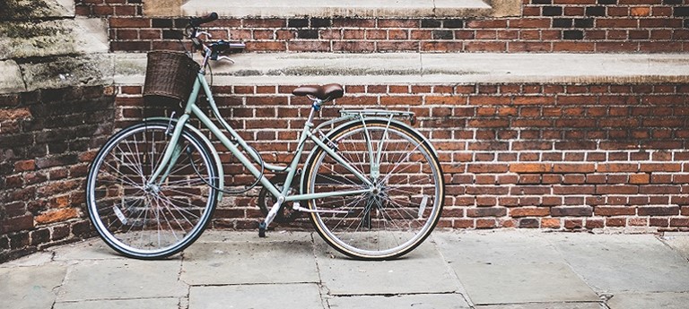 Photo of a bike leaning against a brick wall in Cambridge.