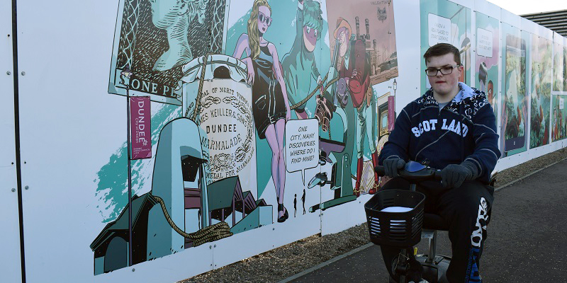 Photo of Gordon beside street art.