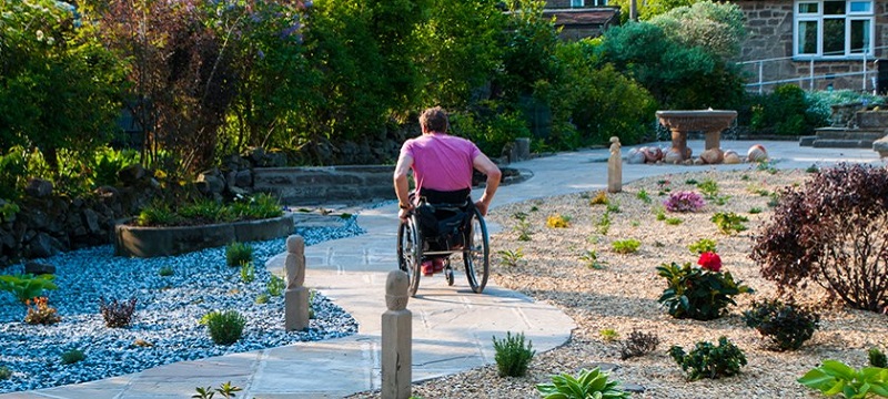 Photo of a wheelchair user exploring the garden.