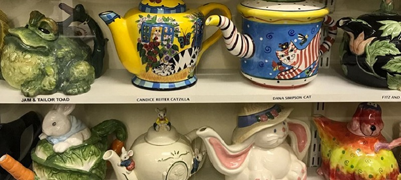 Photo of a shelf full of quirky teapots.