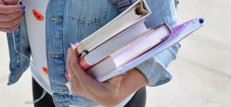 Photo of a student holding some books.