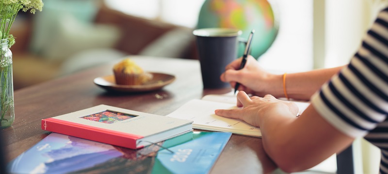 Photo of a person writing at a desk.