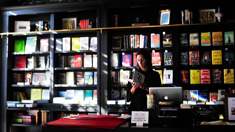 Photo of a bookshop showing shelves and a till.