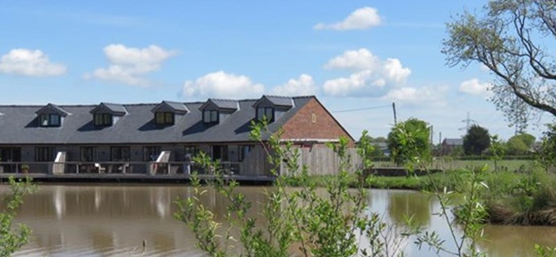 Photo of a row of cottages by a lake on a sunny day.