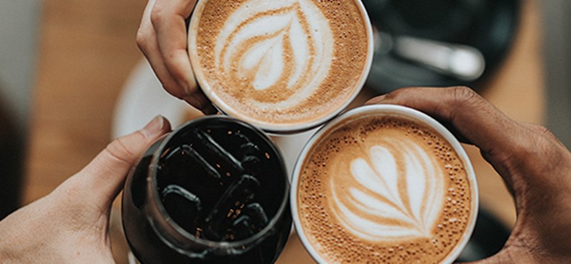 Photo of hands holding coffee.