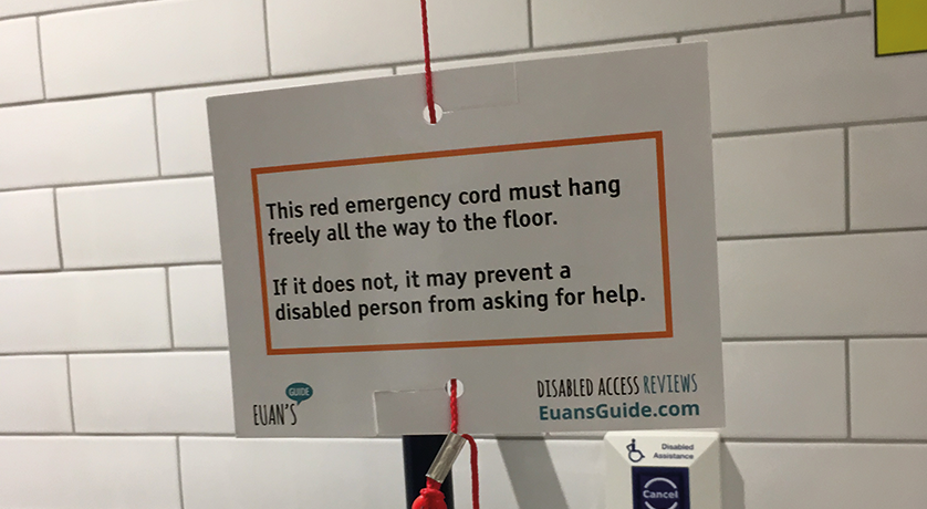 Image of a Red Cord Card attached to a red emergency cord in a toilet