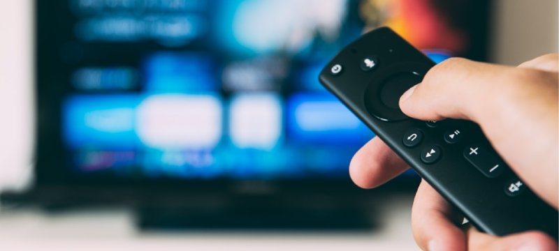Image of someone using a remote to choose what to watch