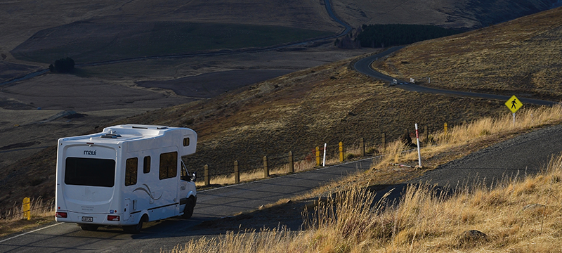 Image of a caravan driving on a country road.