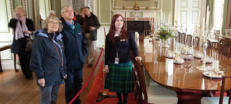 Image of a staff member assisting visitors at a historic venue.