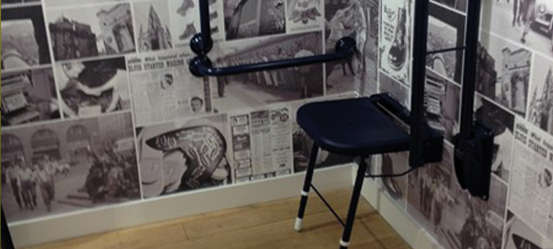 Image showing a seat and railings in an accessible fitting room.