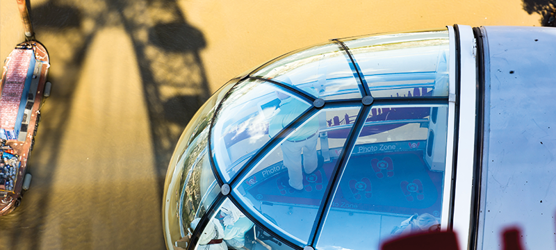 Close up image of one of the London Eye capsules with a boat seen below in the River Thames.