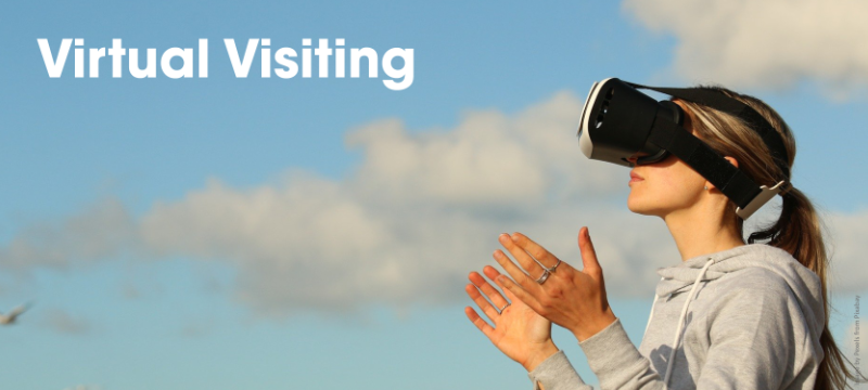 Someone wearing a virtual reality headset outdoors with text reading "virtual visiting".