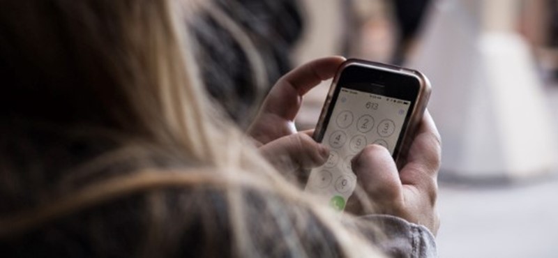 Image of a woman on her phone, her back it turned. 