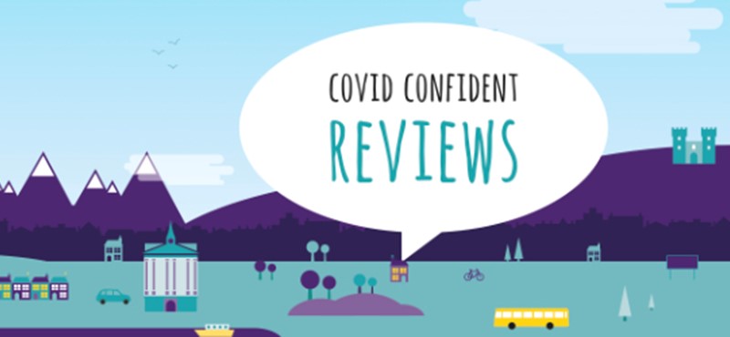 Generic cityscape with a speech bubble. Test in the speech bubble reads "Covid Confident reviews".