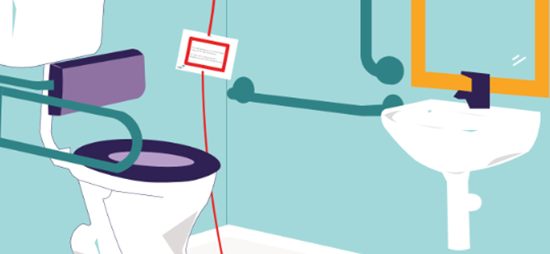 An accessible toilet with grab rails and a red emergency cord