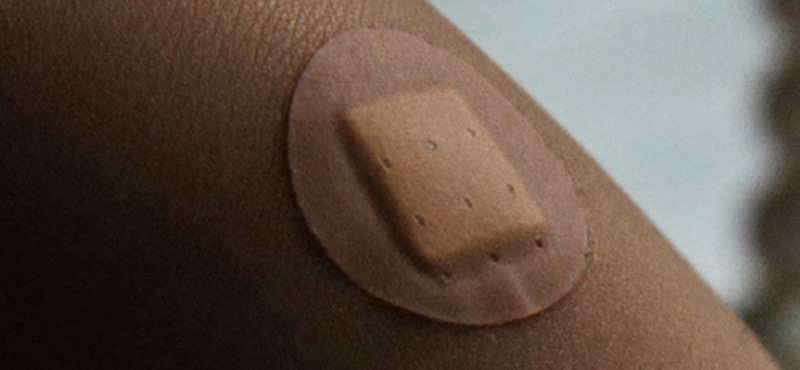 A close up of someone's arm with a small circular plaster on it