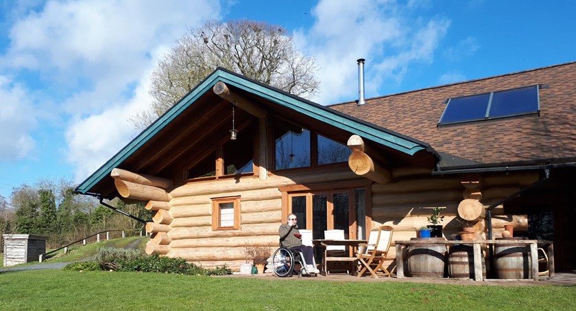 Person with a hot drink outside the Ludlow Ecolog Cabins