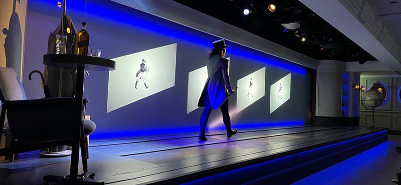 An actor dressed as Johnnie Walker walking across the stage at Johnnie Walker Princes Street.