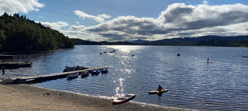 Boats in Loch Insh next to the sandy beach.