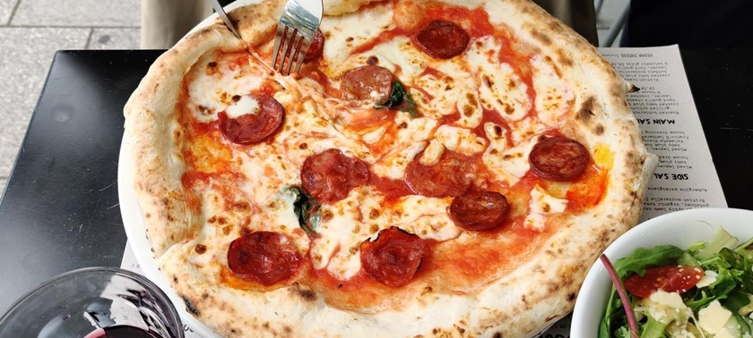 Somebody cutting into a pepperoni pizza at Franco Manca