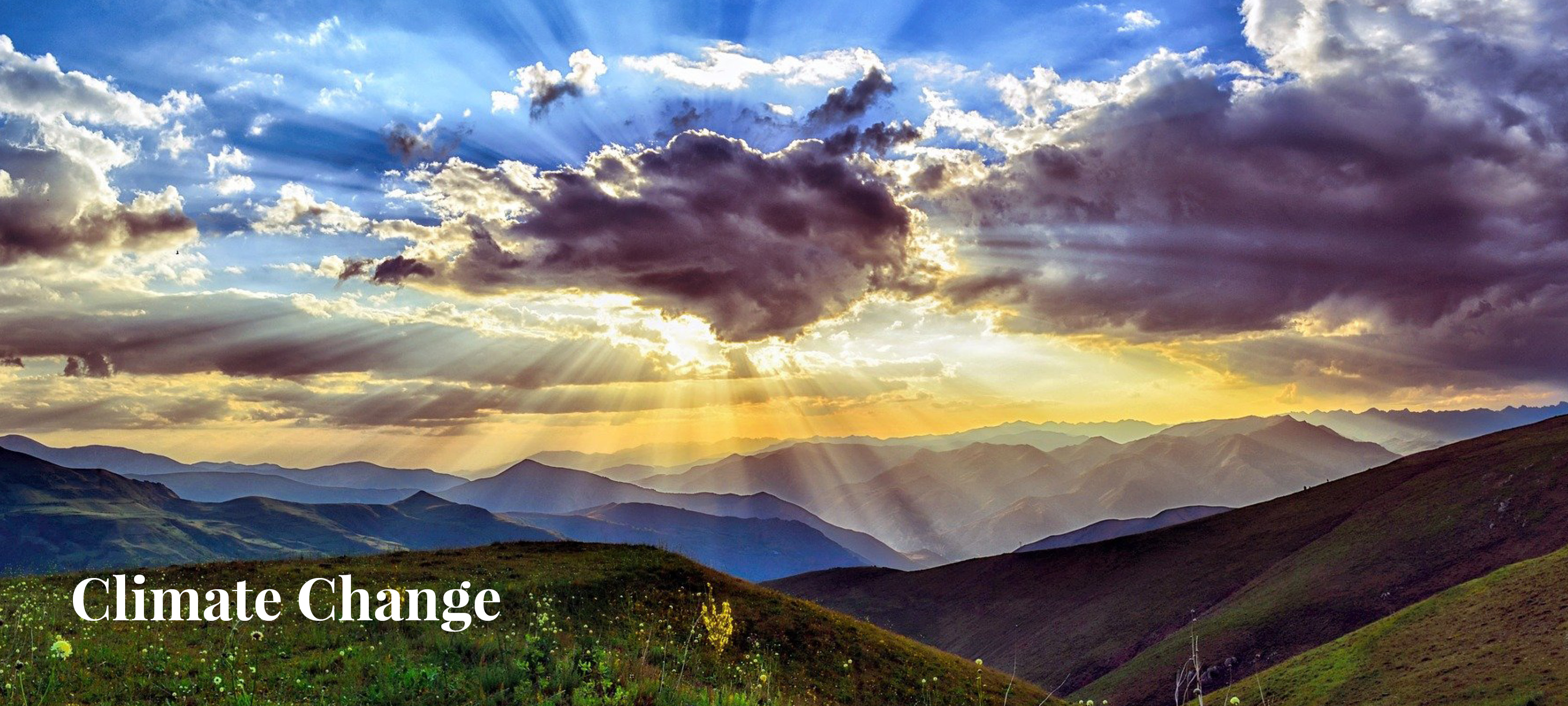 A picture of the sky with clouds and the sun shining behind them, with rolling hills in the backdrop. Text on the left reads: "Climate Change"