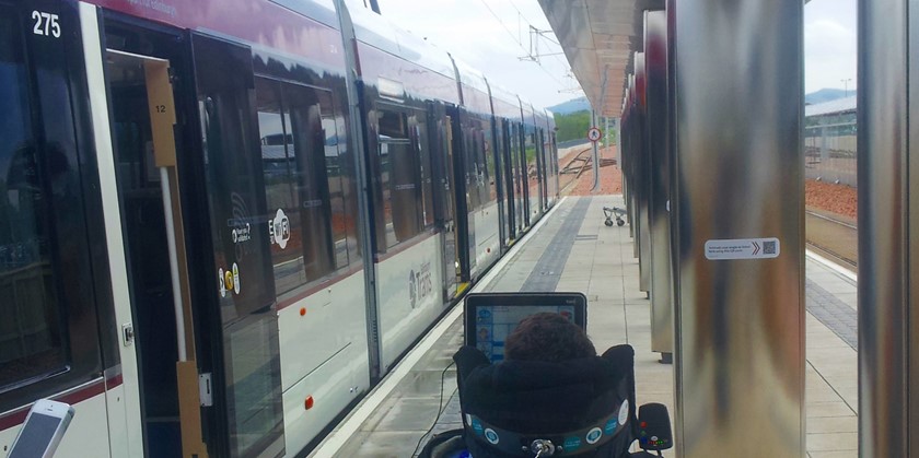 A tram with a wheelchair just outside.