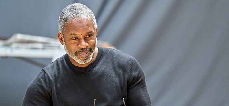 A photo of a man looking off slightly off camera while rehearsing